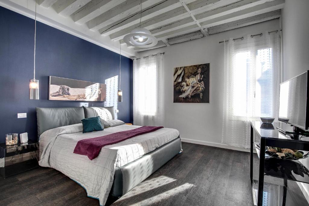 1 dormitorio con 1 cama grande y paredes azules en Biennale superior suite, en Venecia