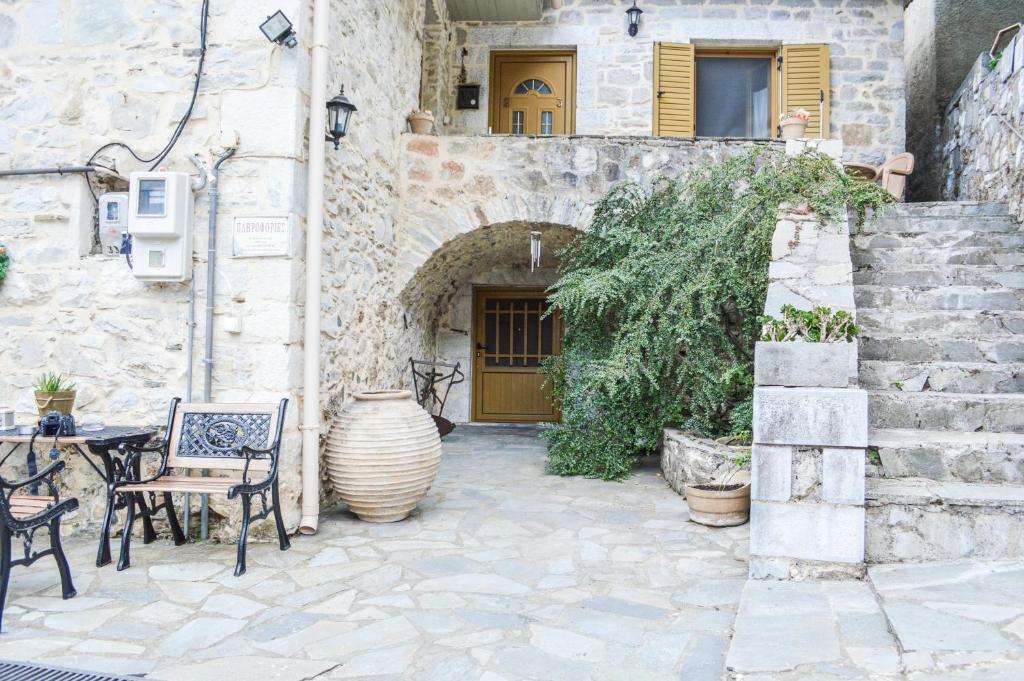 a patio area with a stone wall and a stone staircase at Lamprou in Kosmas