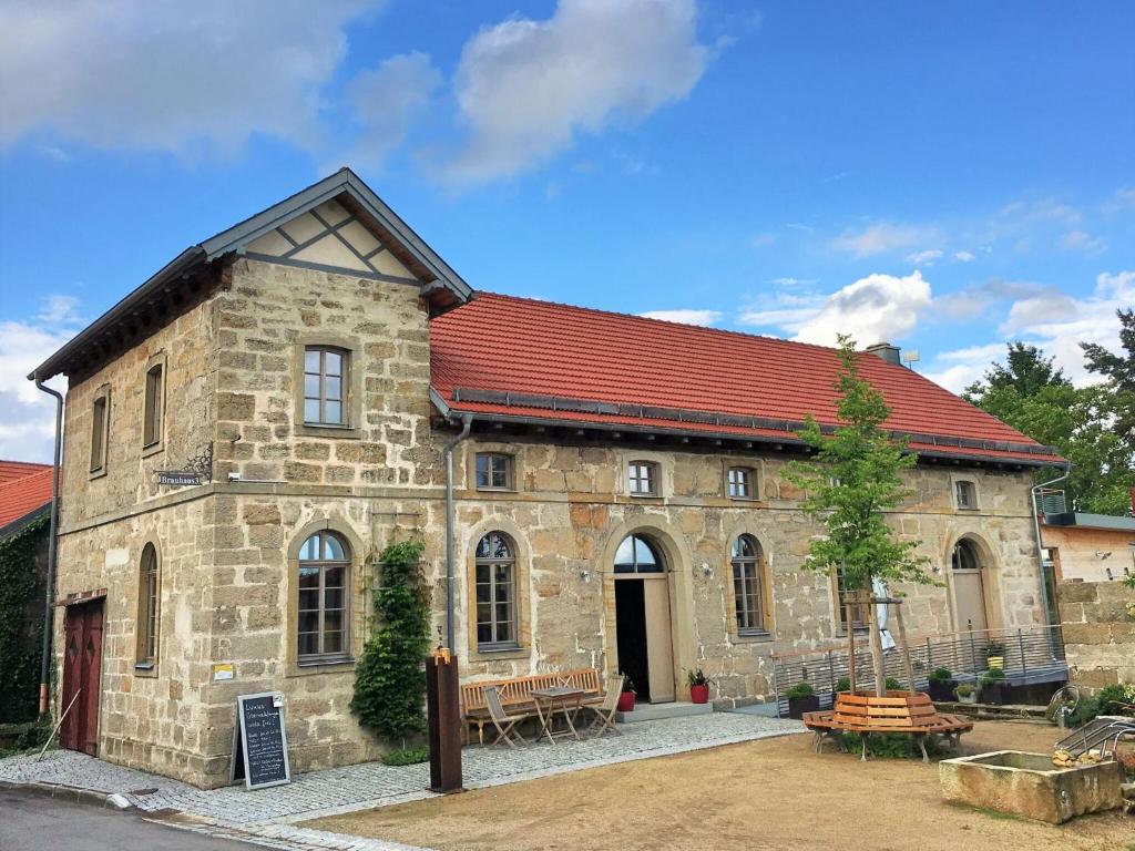 un gran edificio de piedra con techo rojo en Doppelzimmer Brauhaus 3 en Königsberg in Bayern