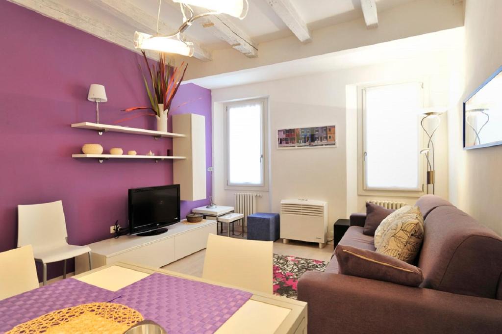 un soggiorno con pareti viola, divano e tavolo di Venetian Dream in Biennale area a Venezia