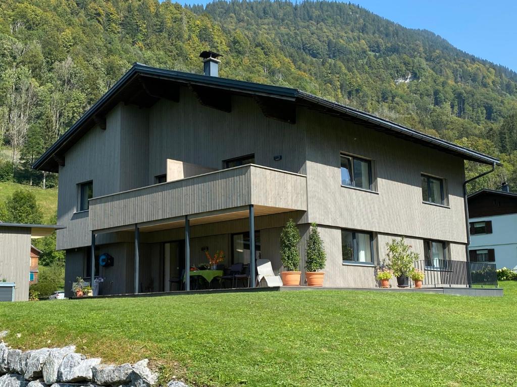 duży dom z zielonym trawnikiem przed nim w obiekcie Ferienwohnung Übelher w mieście Schnepfau
