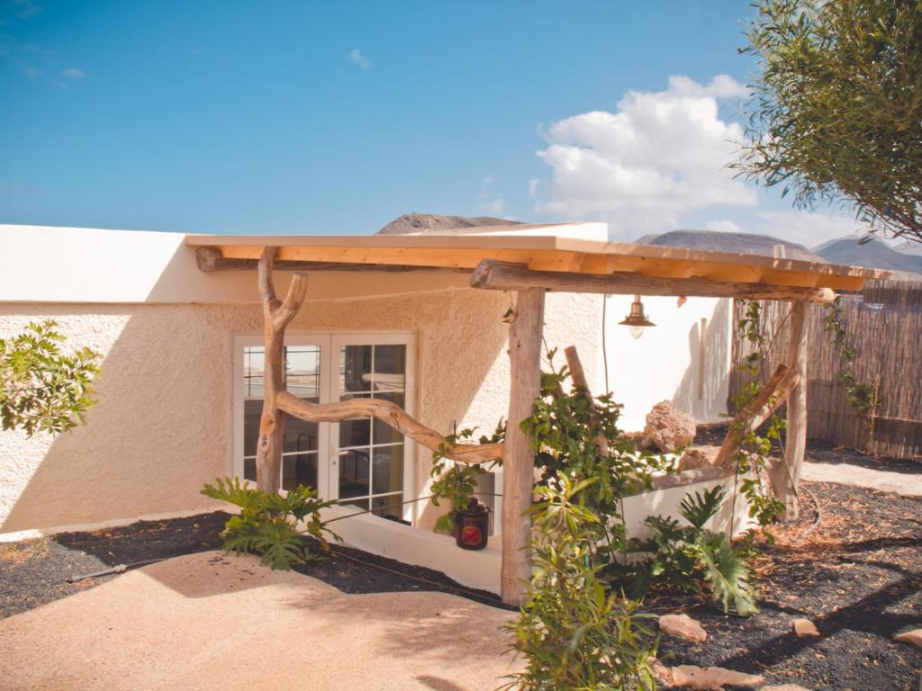 a house with a pergola in the yard at Gartenappartement - Tierra - Surf & Yoga Villa in La Pared