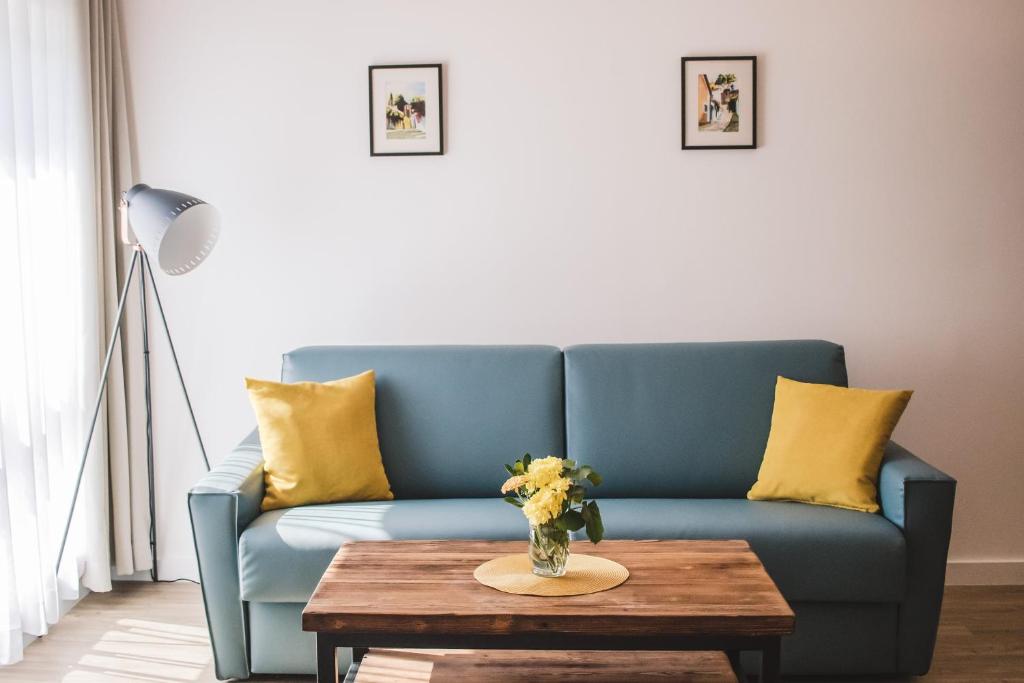 a blue couch with yellow pillows and a table at Mathias Rex in Szentendre