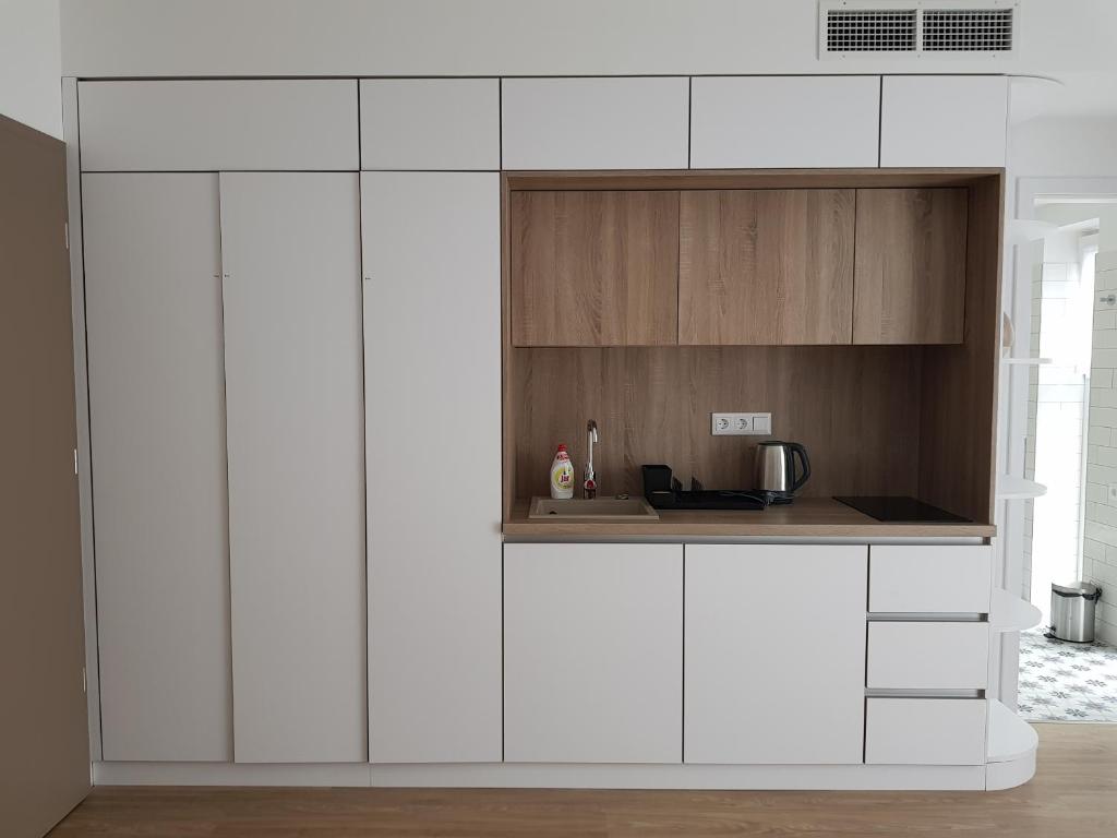 a kitchen with white cabinets and a counter at Mathias Rex in Szentendre
