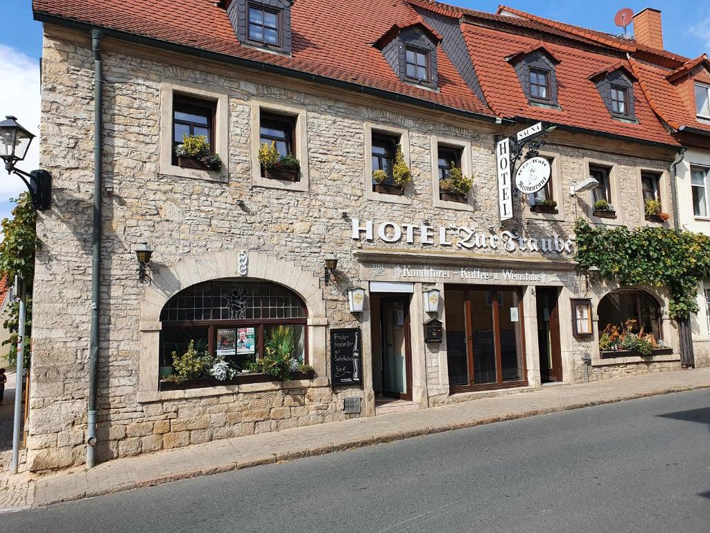 um antigo edifício de pedra ao lado de uma rua em Hotel Zur Traube em Freyburg