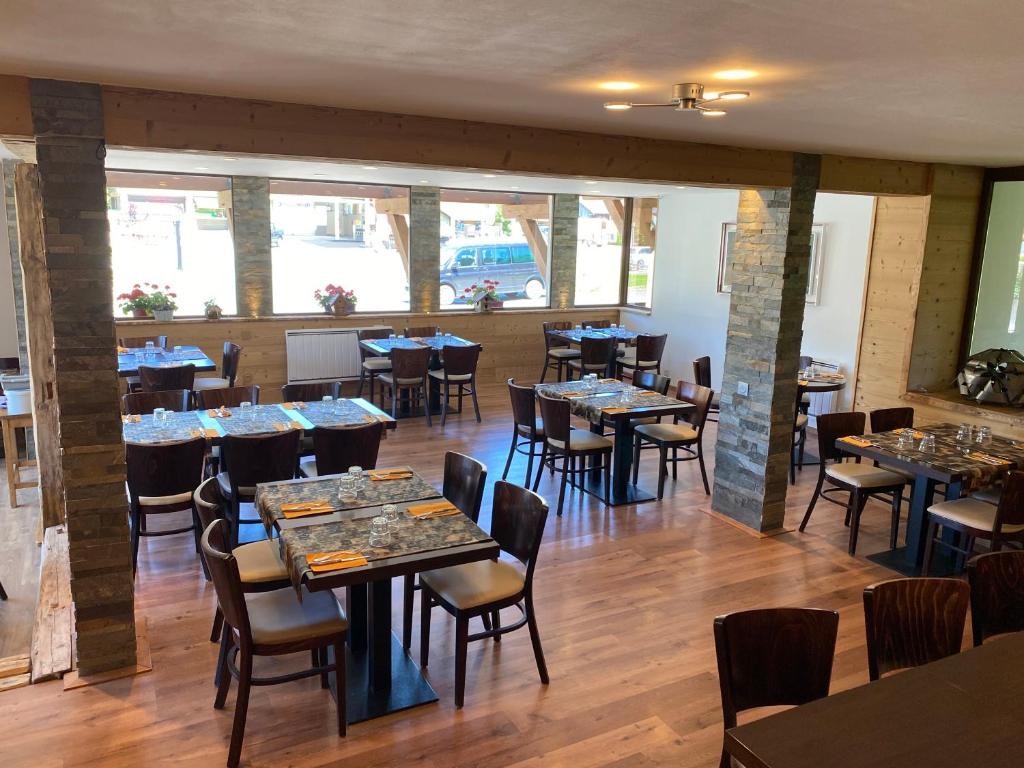 a restaurant with tables and chairs in a room at Hôtel Rent in Megève