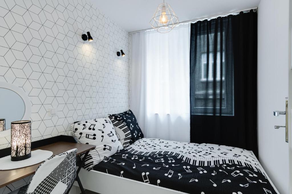 Un dormitorio pequeño con una cama y un escritorio. en Crystal Apartment Katowice III, en Katowice