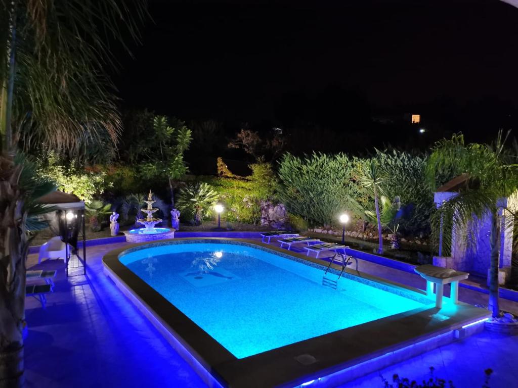 - une piscine avec des lumières bleues la nuit dans l'établissement villa Giò, à Racalmuto