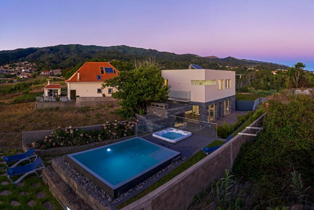 a house with a swimming pool on a hill at Casa da Maloeira by An Island Apart in Fajã da Ovelha
