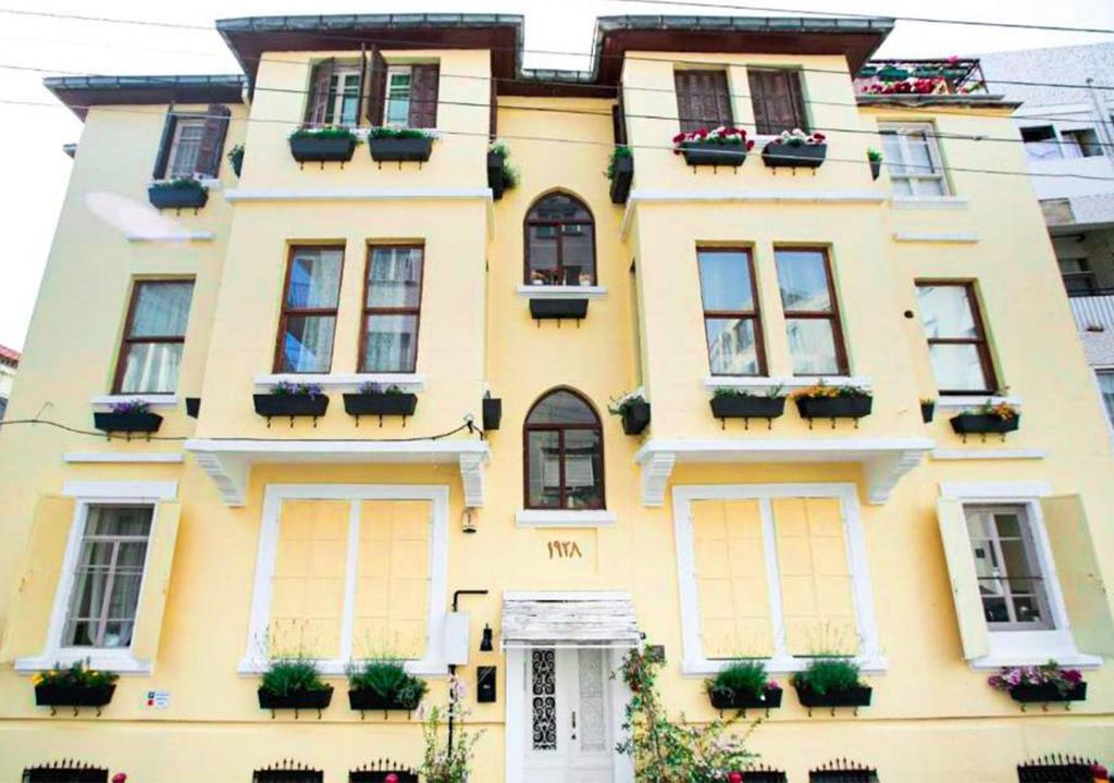 a yellow building with potted plants on it at Historical Ottoman Manor in İzmir