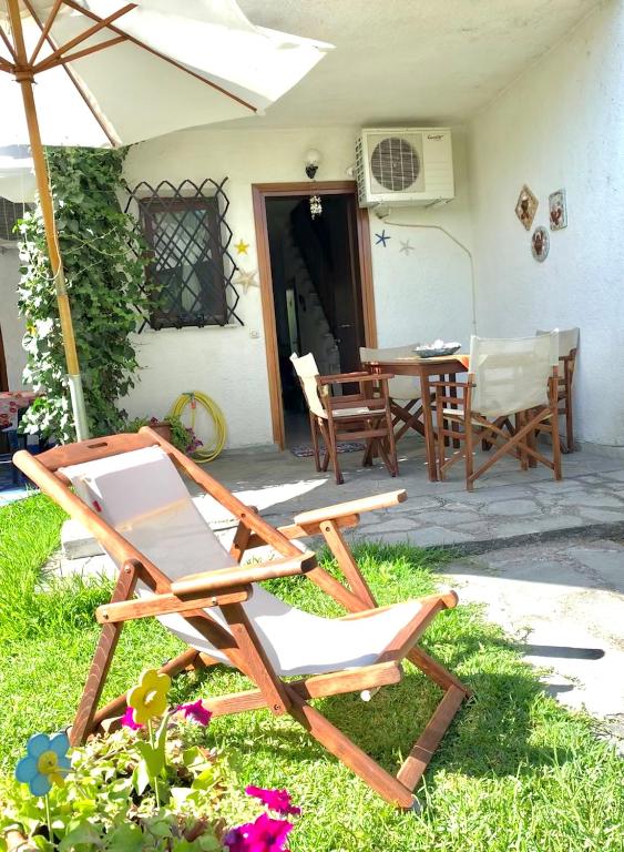 a patio with chairs and a table and an umbrella at Stella's Maisonette in Siviri