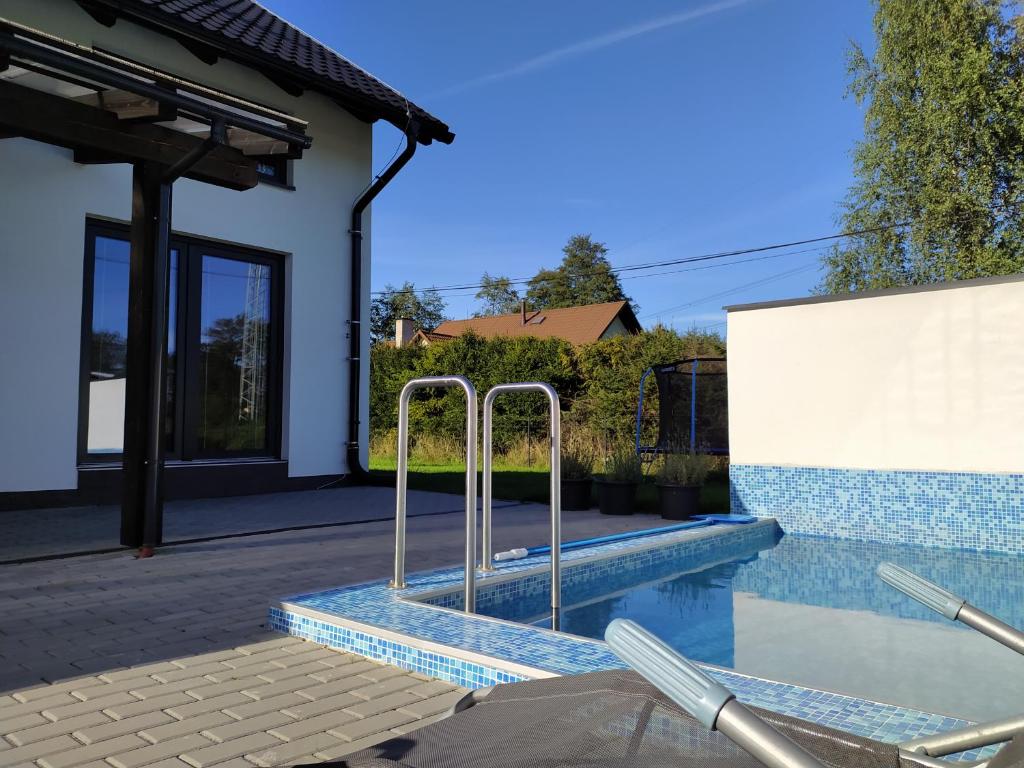 - une piscine avec des bars en métal dans une maison dans l'établissement Apartmány U Kempu, à Dolní Lomná