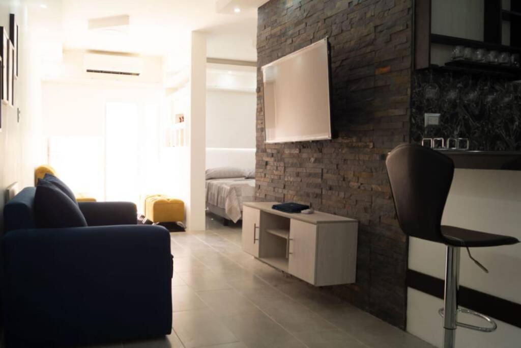 a living room with a black chair and a bed at Remodeled Studio Apt in Guayaquil Centro w a View in Guayaquil