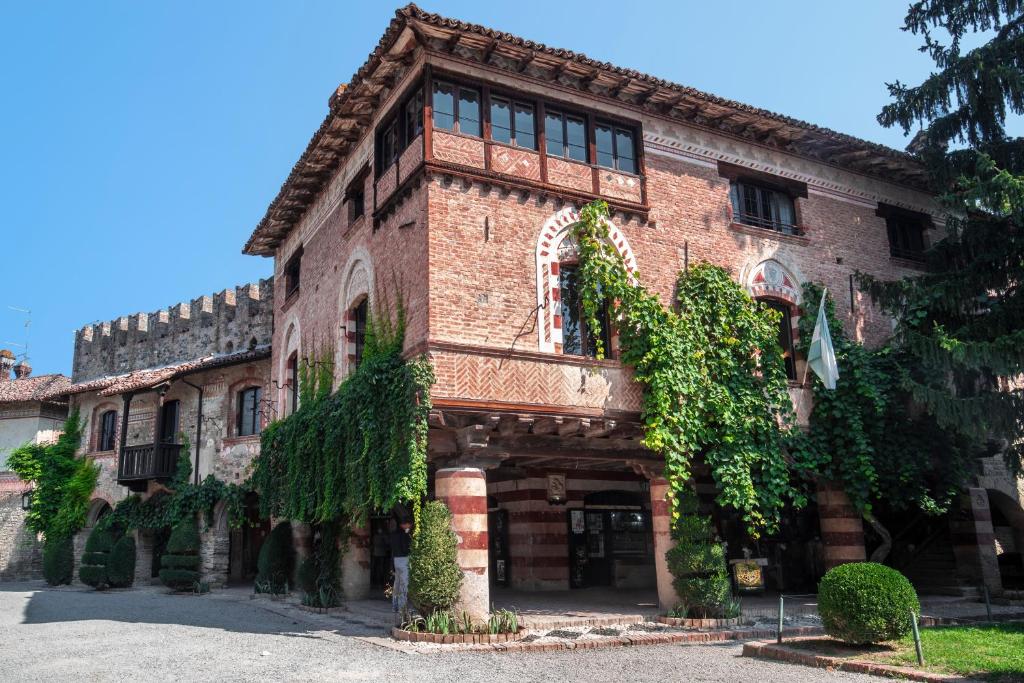 ein großes Backsteingebäude mit Efeu, der darauf wächst in der Unterkunft La Locanda di Grazzano Visconti in Grazzano Visconti