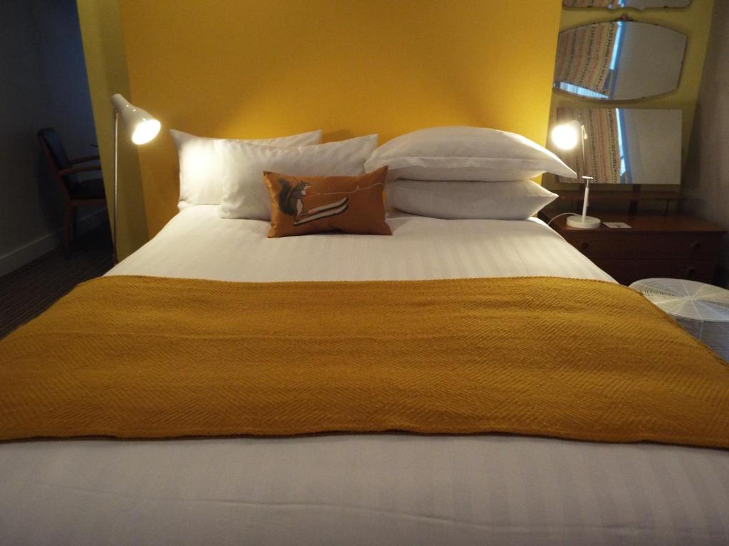 1 cama grande con 2 almohadas encima en Regency Rooms, en Littlehampton