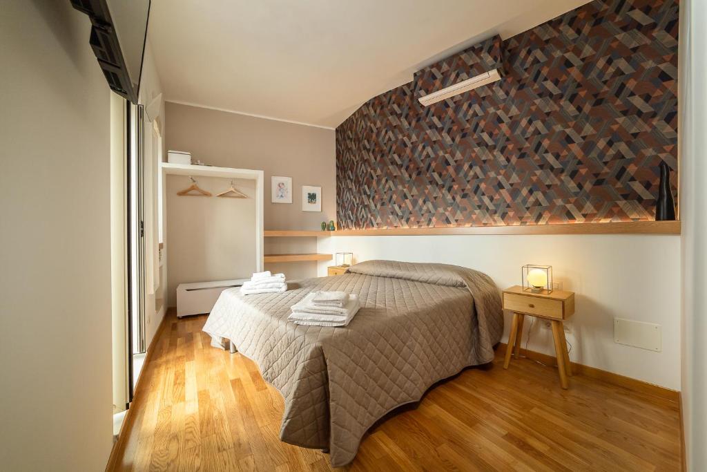 1 dormitorio con 1 cama y pared con botellas de vino en Arco Gentile, en Bitonto