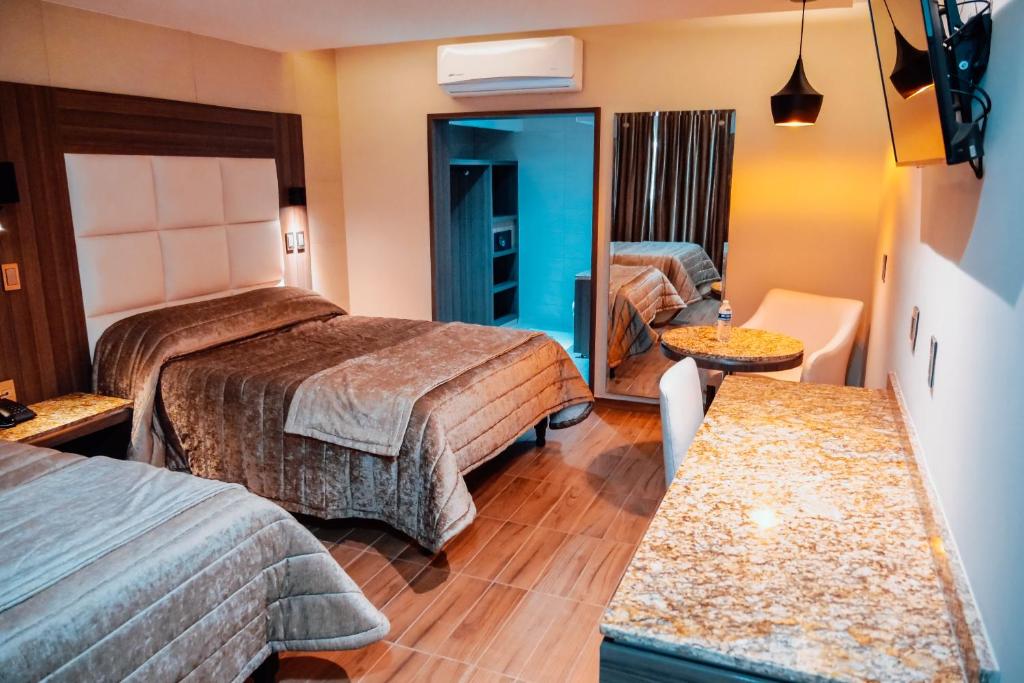 een hotelkamer met 2 bedden en een spiegel bij KAVIA MEOQUI HOTEL & SUITES in Meoqui