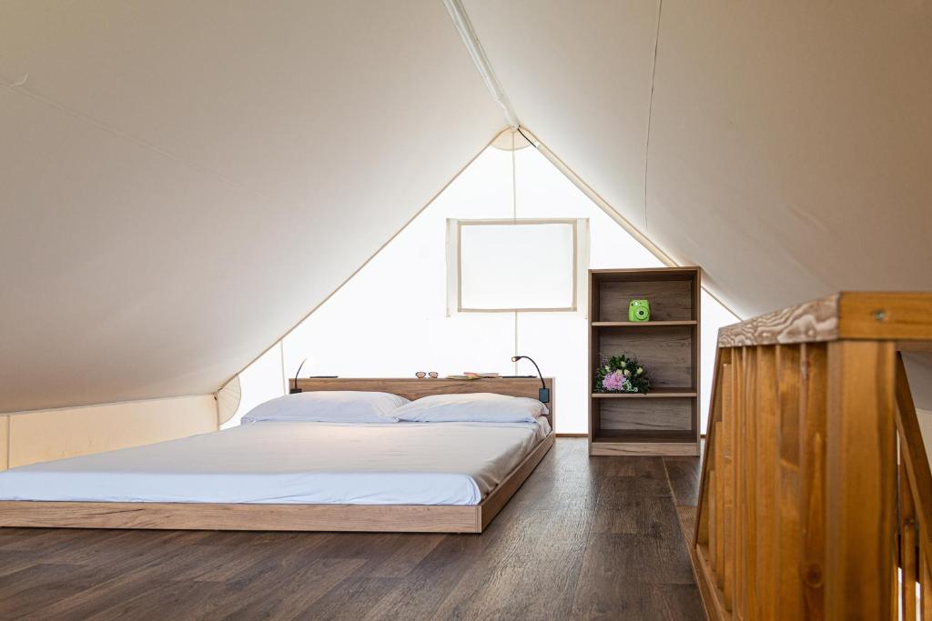 a bedroom with a large bed in a attic at Nabi Resort Glamping & SPA in Castel Volturno