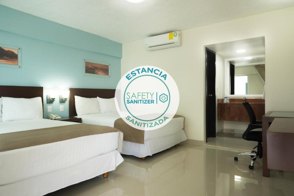 una camera d'albergo con due letti e un cartello di Hotel Casa Blanca a Chetumal