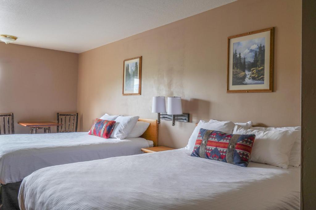 a hotel room with two beds and a table at Whitewater Inn in Big Sky