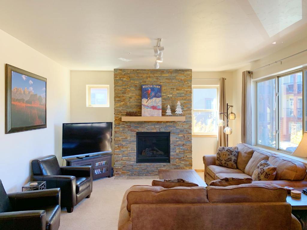 Una sala de estar con un sofá y una chimenea. en Trailhead Lodges Building 401 Unit 422, en Winter Park