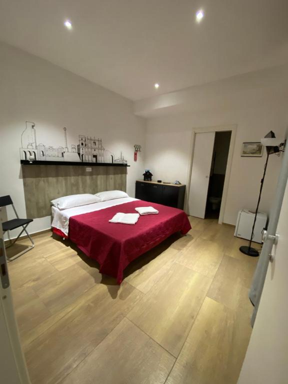 - une chambre avec un lit et une couverture rouge dans l'établissement Handy, à Brindisi