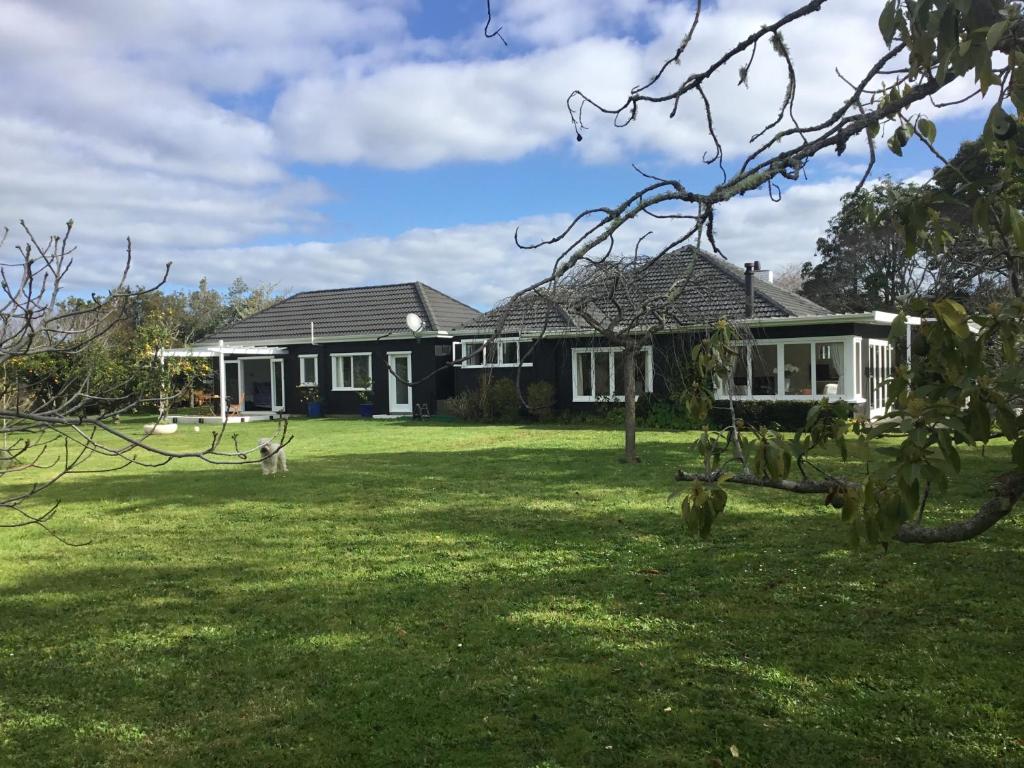 una casa con un patio verde delante de ella en Pa Road B&B Kerikeri NZ, en Kerikeri