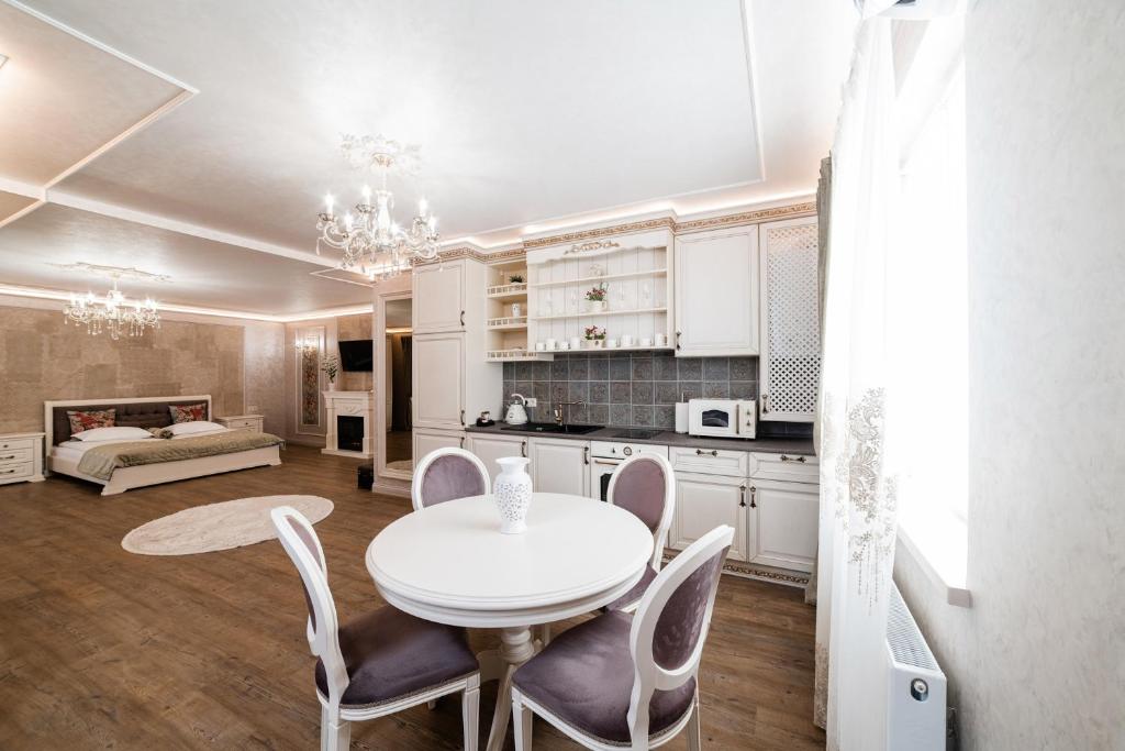 a kitchen and dining room with a white table and chairs at VIP apartment on Duhnovicha street .Free parking. in Uzhhorod