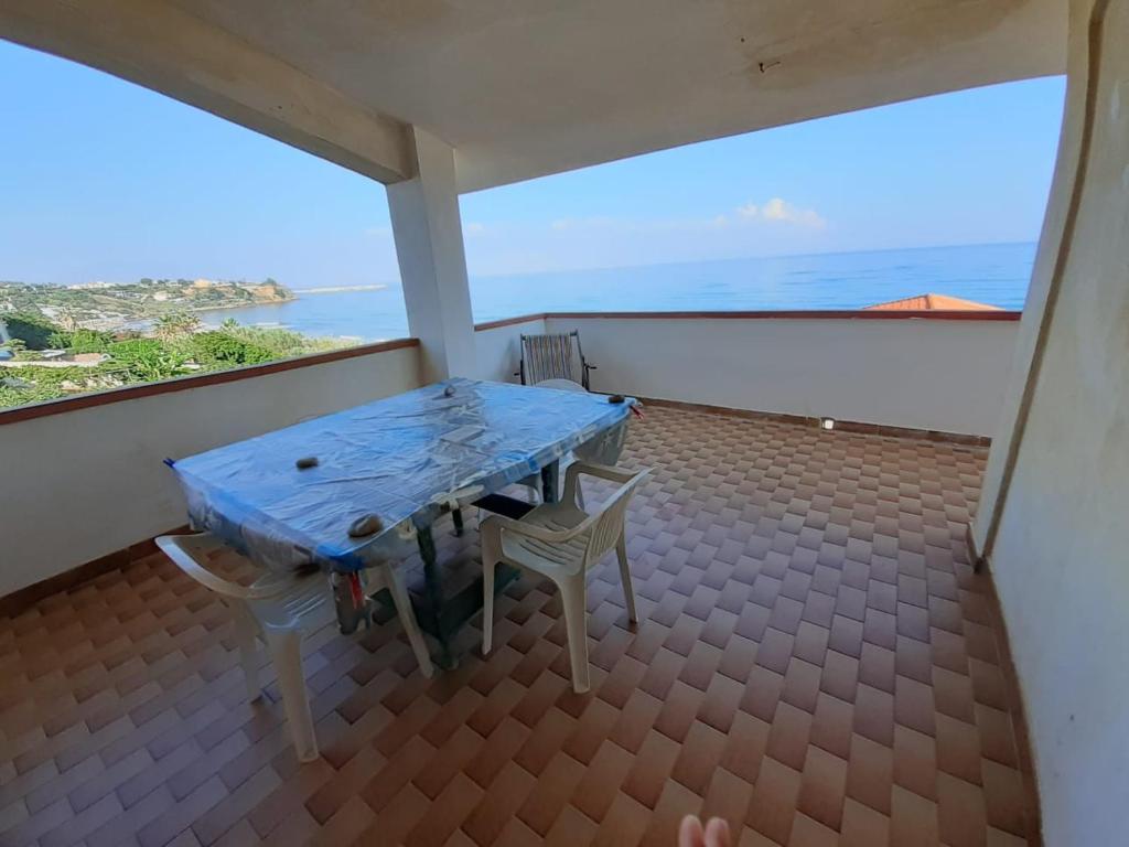 stół i 2 krzesła na balkonie z widokiem na ocean w obiekcie la finestra sul mare piano 2 w mieście Trappeto