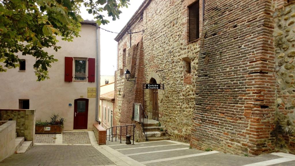 an alley between two buildings with a red door at Maison au pied de la cathédrale in Elne