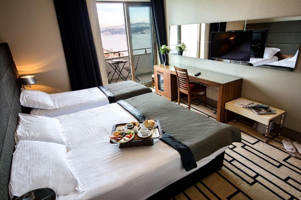 a hotel room with a large bed with a tray of food on it at Cihangir Hotel Bosphorus in Istanbul