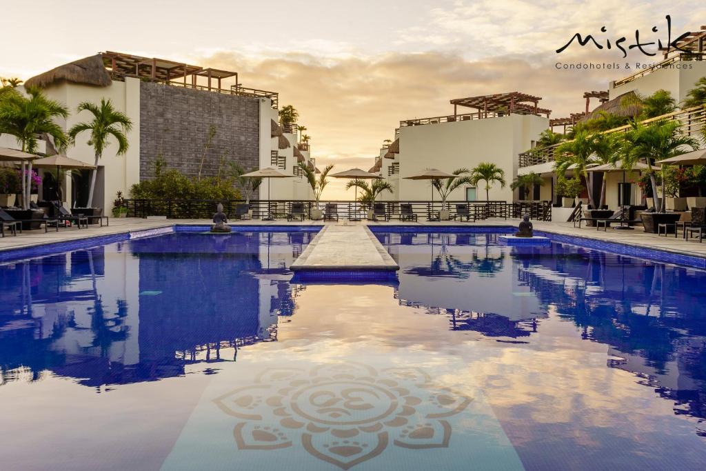 a swimming pool in front of some buildings at Aldea Thai by Mistik Vacation Rentals in Playa del Carmen