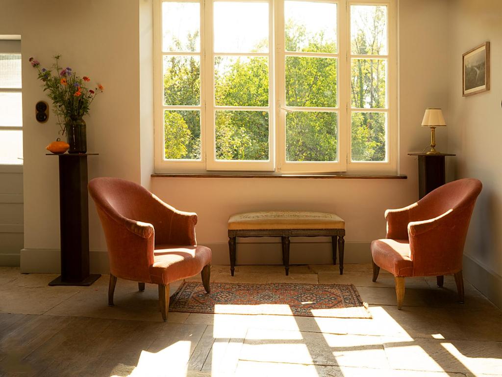 2 sillas y un banco en una habitación con ventana en The Riverhouse, magical house with garden by the river Seine, en Gyé-sur-Seine