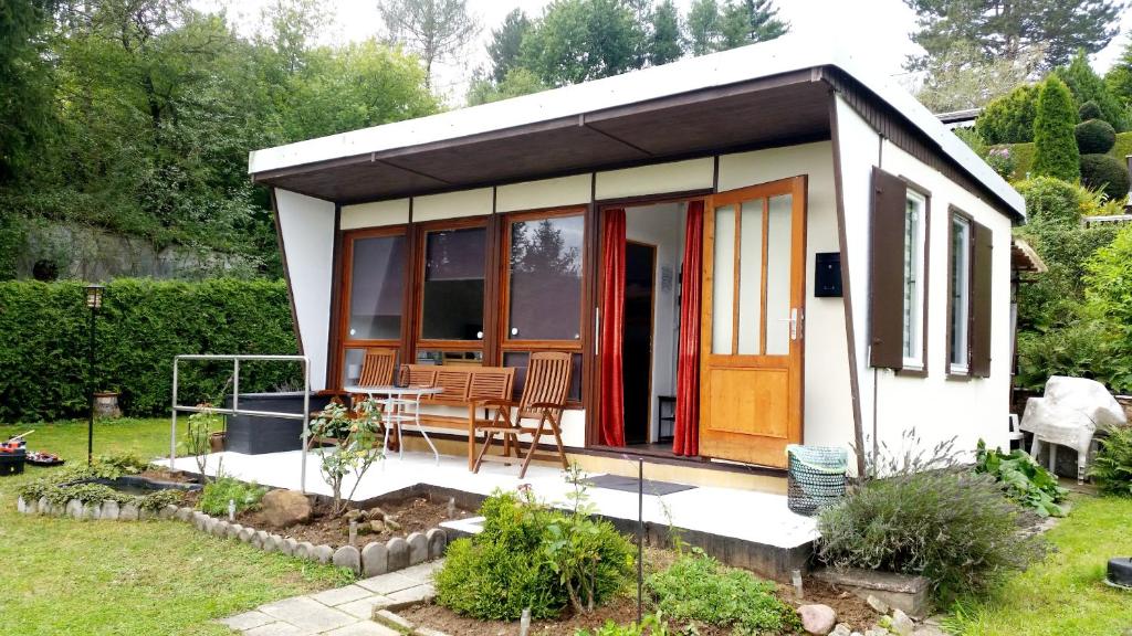 a small cottage with a table in a garden at Talblick 1 - Ihr Zuhause : das Ferienhaus mitten im idyllischen Tal in Bad Bibra