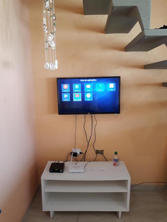 a living room with a tv on a wall at Sarau's Beach House Boracéia in Boracéia