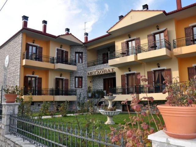 a large apartment building with balconies and a courtyard at Megdovas Hotel in Kalyvia