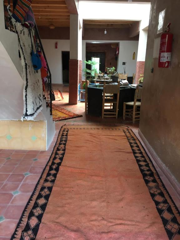 - un couloir avec un tapis rouge au sol dans l'établissement Maison D'hôtes Dar Afra, à Aït Ziri