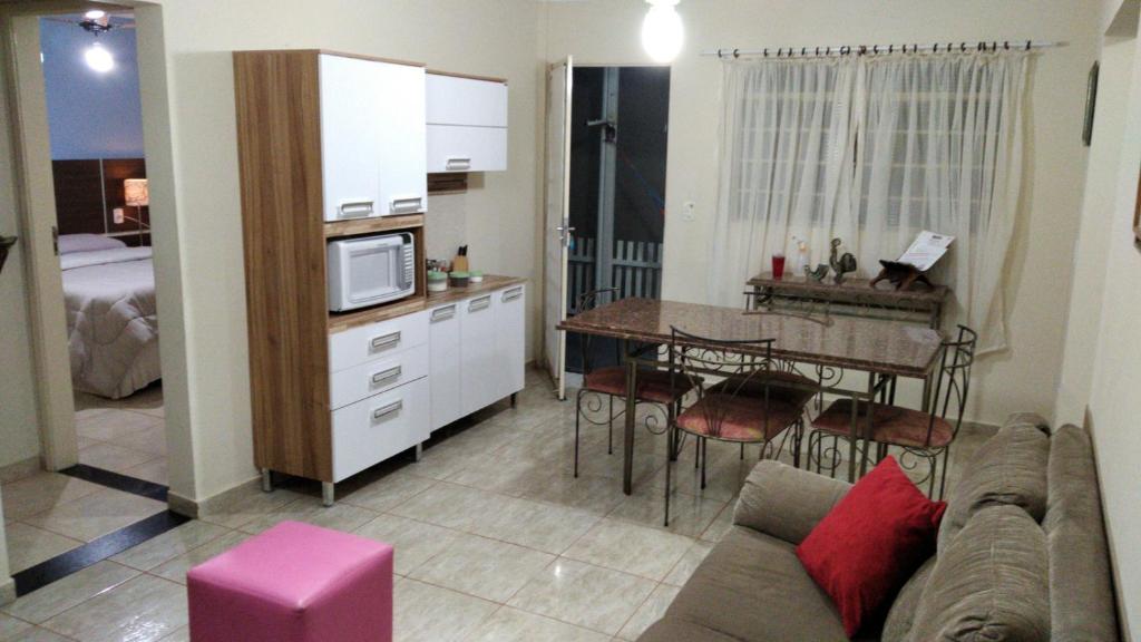 a living room with a couch and a kitchen with a table at Casa 2 dorm em Botucatu próx unesp in Botucatu