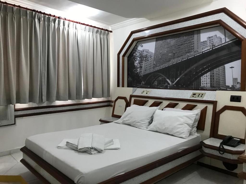 Un dormitorio con una cama con dos libros. en Paissandú Palace Hotel - Próximo às ruas 25 de Março, Sta Ifigênia e regiões do Brás e Bom Retiro, en São Paulo