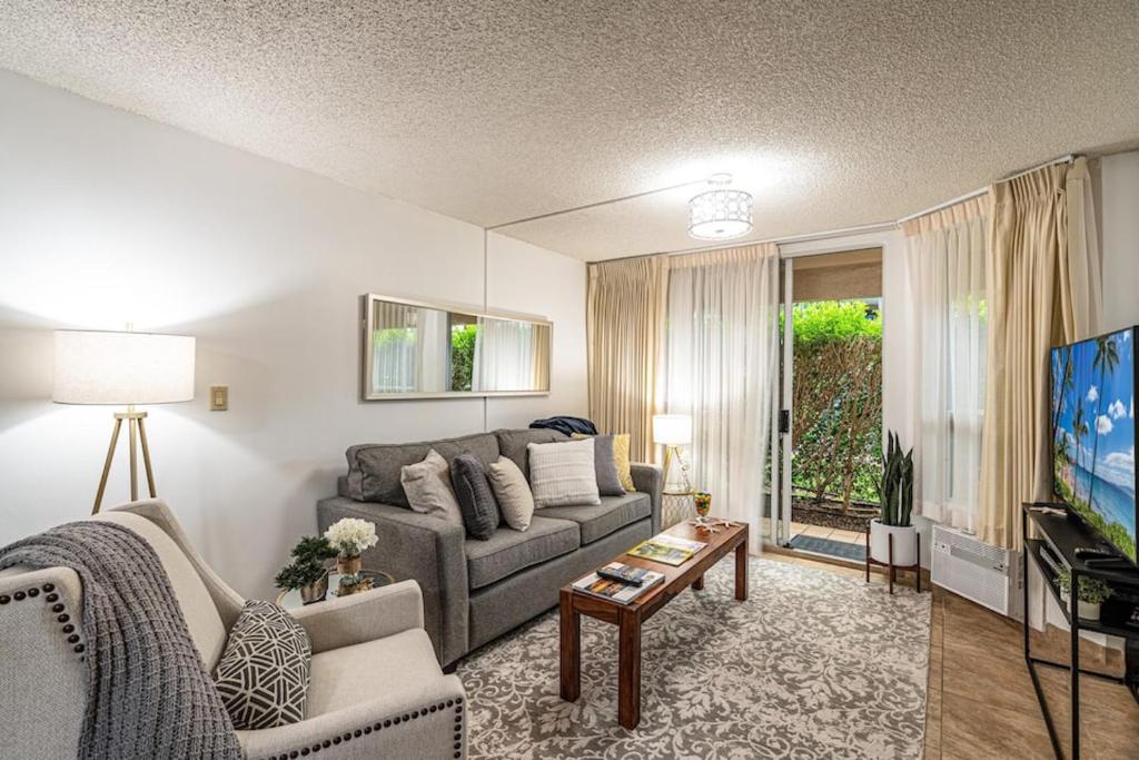 a living room with a couch and a tv at 1 BD King Suite: 40% OFF, Beach Walk in Wailea