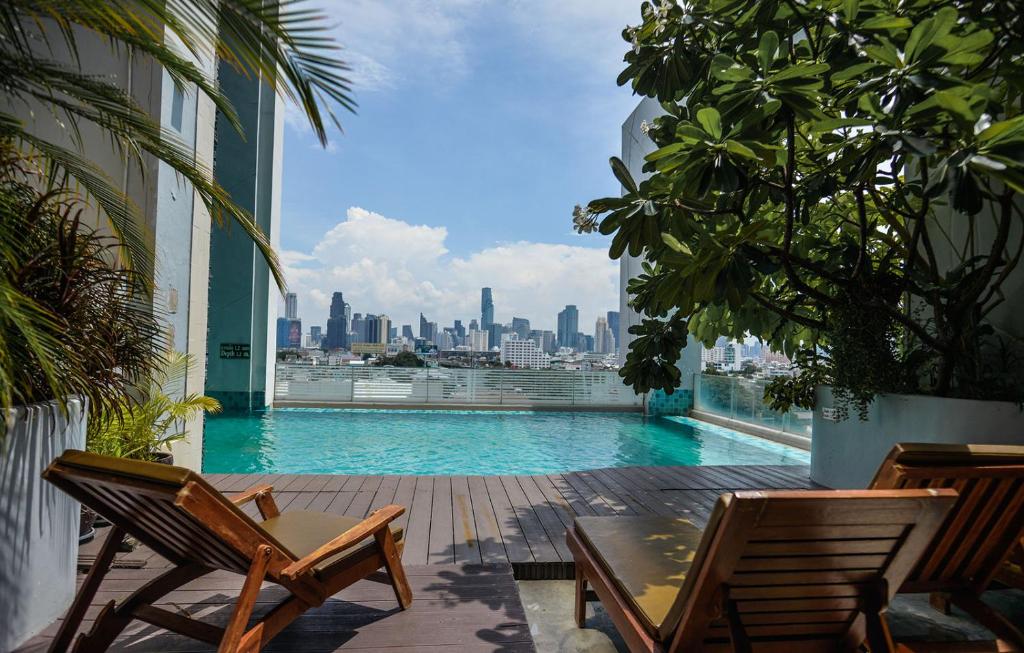 a balcony with a pool and a view of a city at Grand Howard Hotel Bangkok in Bangkok