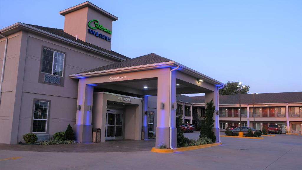 un edificio de hospital con columnas púrpuras en un estacionamiento en Catoosa Inn & Suites, en Catoosa