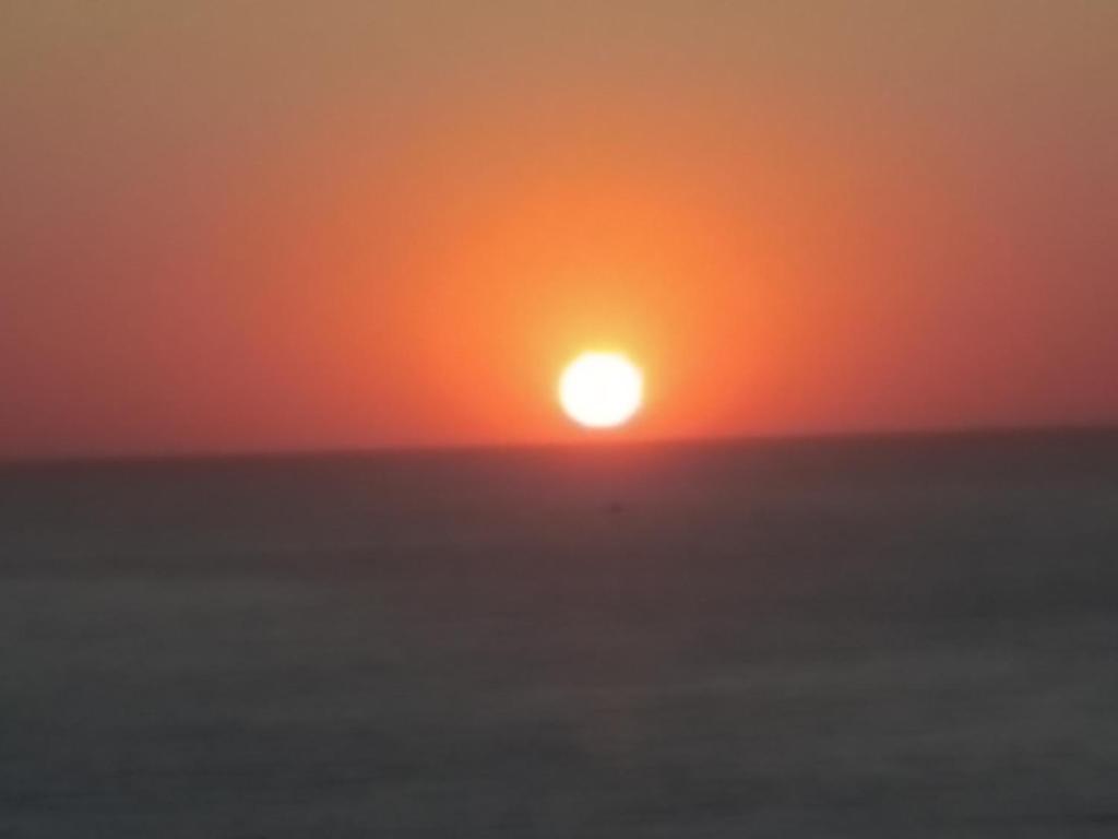 a sunset over the ocean with the sun in the sky at Guesthouse To Petrino 1 in Keramídhion