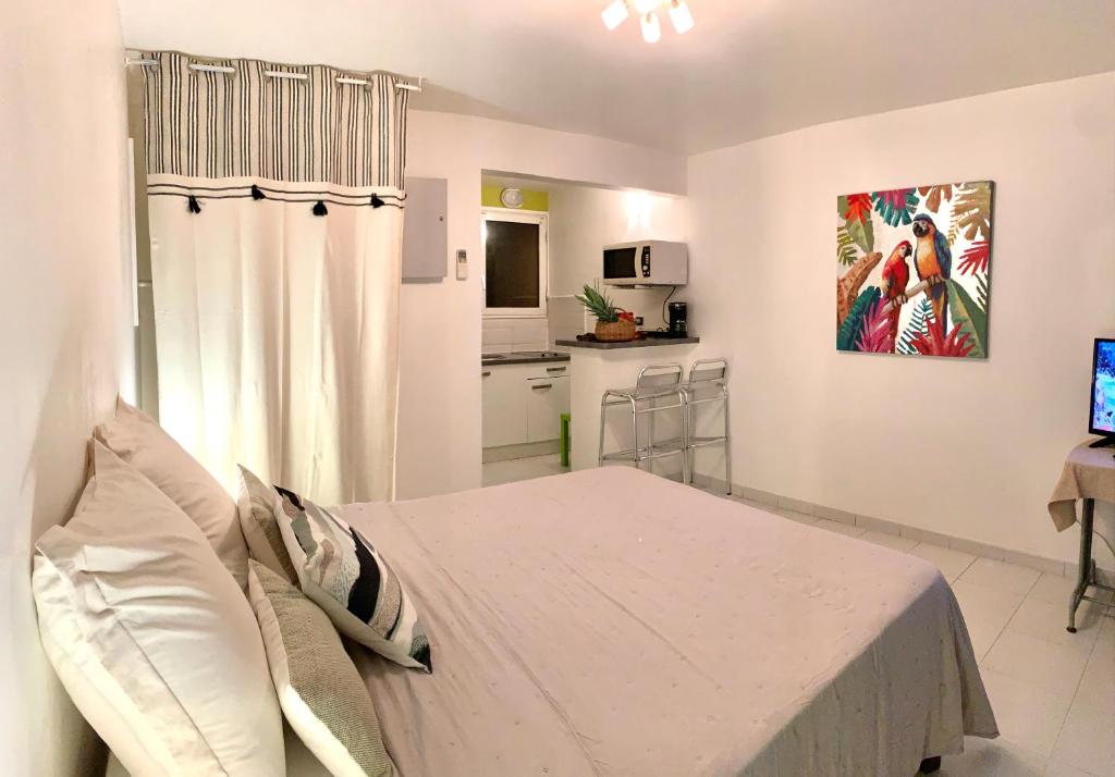 Biała sypialnia z łóżkiem i kuchnią w obiekcie Superbe Studio Ultra COSY à 2 min de la PLAGE w mieście Sainte-Anne