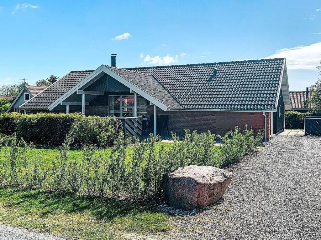 ein Haus mit Baumstumpf davor in der Unterkunft 10 person holiday home in Juelsminde in Sønderby