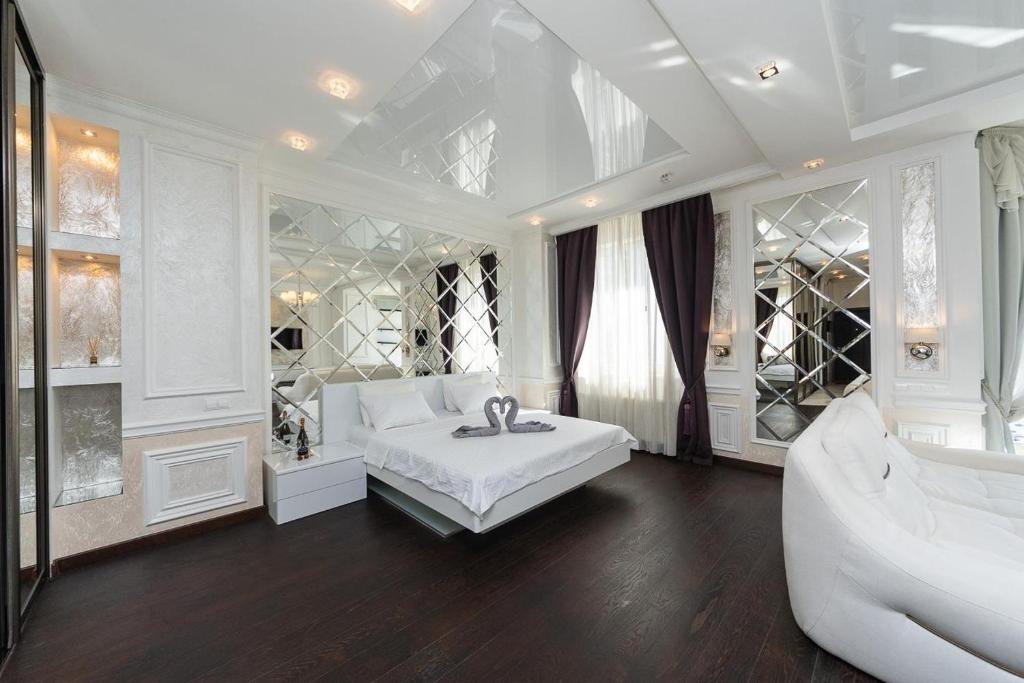 um quarto branco com uma cama grande e um sofá em Exquisite panoramic views apartment Dnipro embankment em Kiev