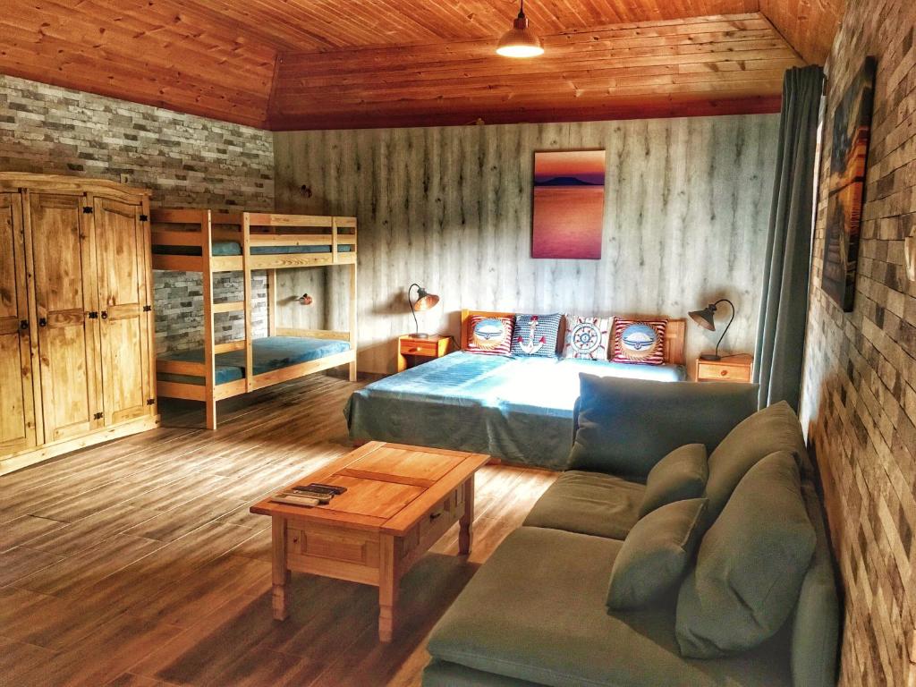 een slaapkamer met een bed en een bank in een kamer bij Káli Pihenőház in Révfülöp