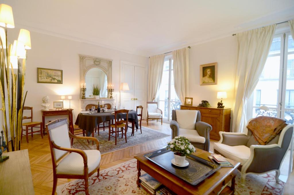 uma sala de estar com mobiliário e uma sala de jantar em Champs Elysees em Paris