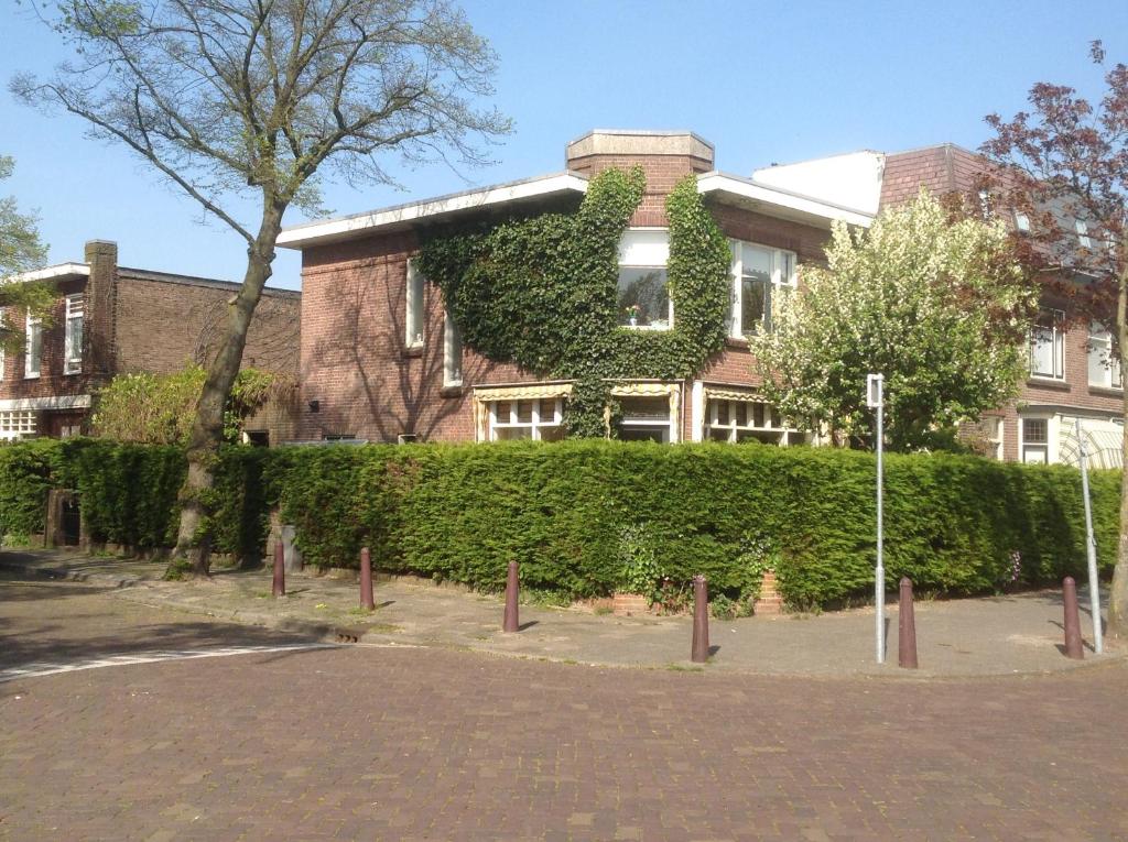un bâtiment avec une haie verte devant lui dans l'établissement Familie Quellhorst, à Leyde