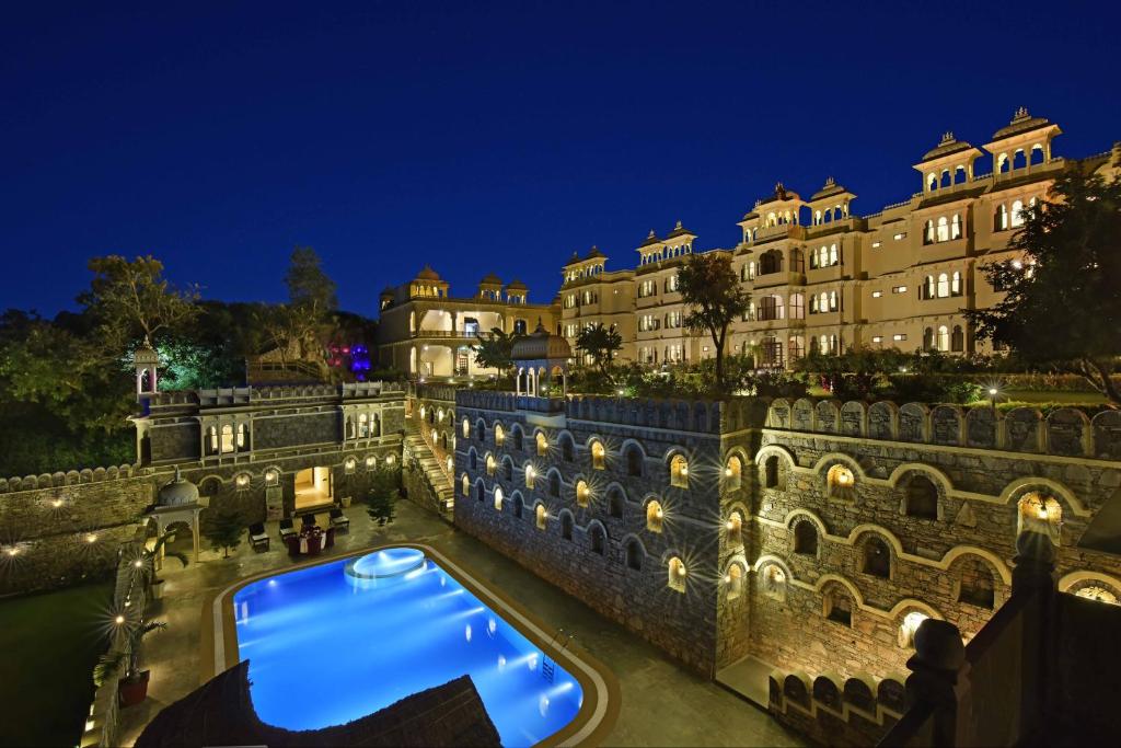 a view of a building at night with a swimming pool at The Kumbha Bagh in Kumbhalgarh